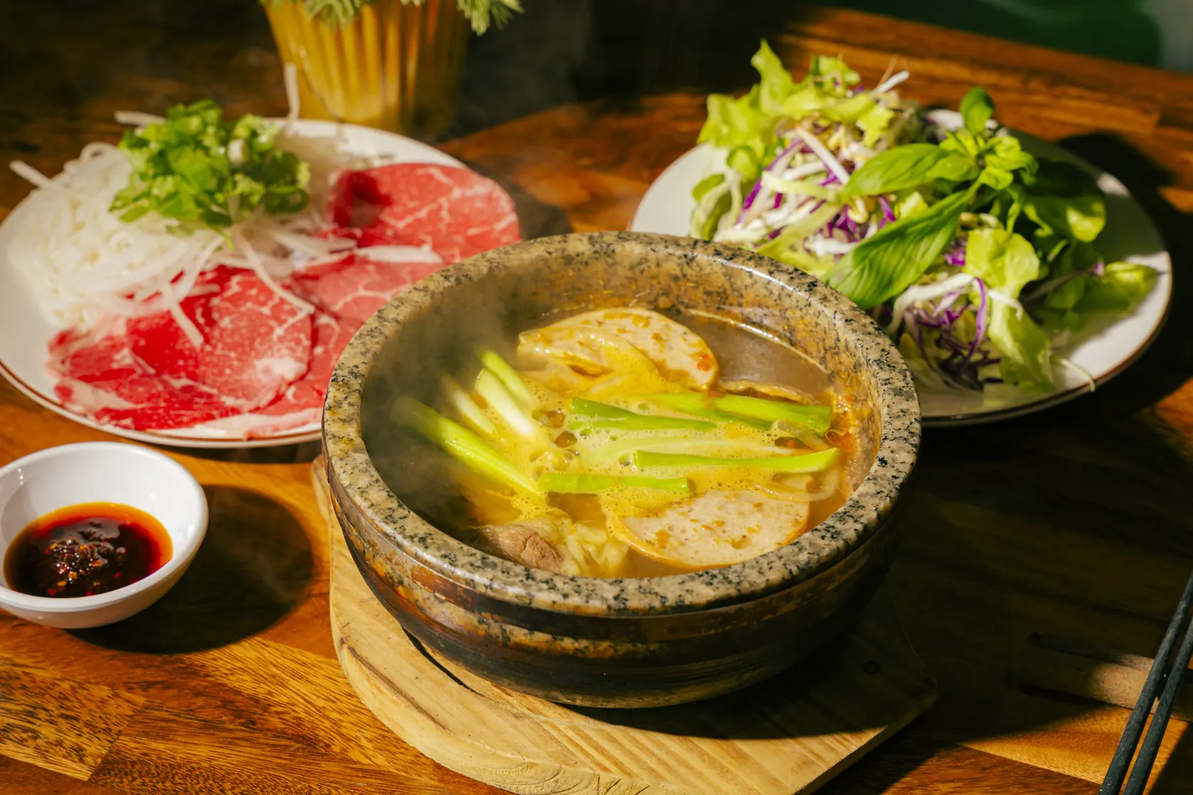 Bún Bò Huế Thố Đá — spicy lemongrass beef and pork noodle soup steaming in a stone bowl at Bà Năm Restaurant, Adelaide
