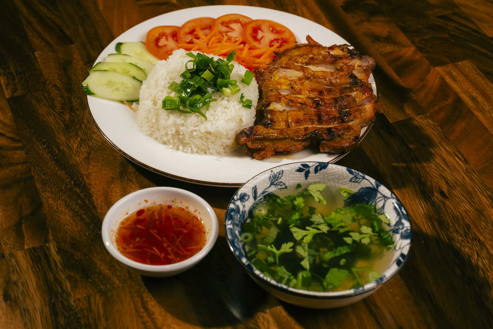 Cơm gà nướng at Bà Năm, Adelaide — char-grilled lemongrass chicken over rice with tomato, cucumber, spring onion, nước chấm and a bowl of canh