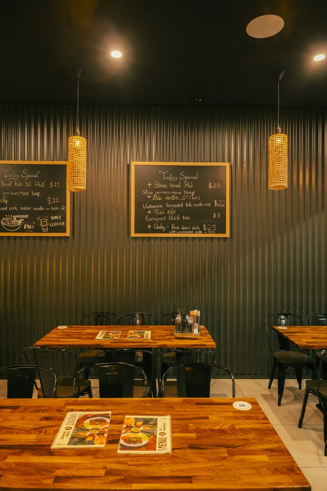 The warm dining room at Bà Năm Restaurant, Adelaide — chalkboard specials and wooden tables, where vegetarian Vietnamese plates are made to order