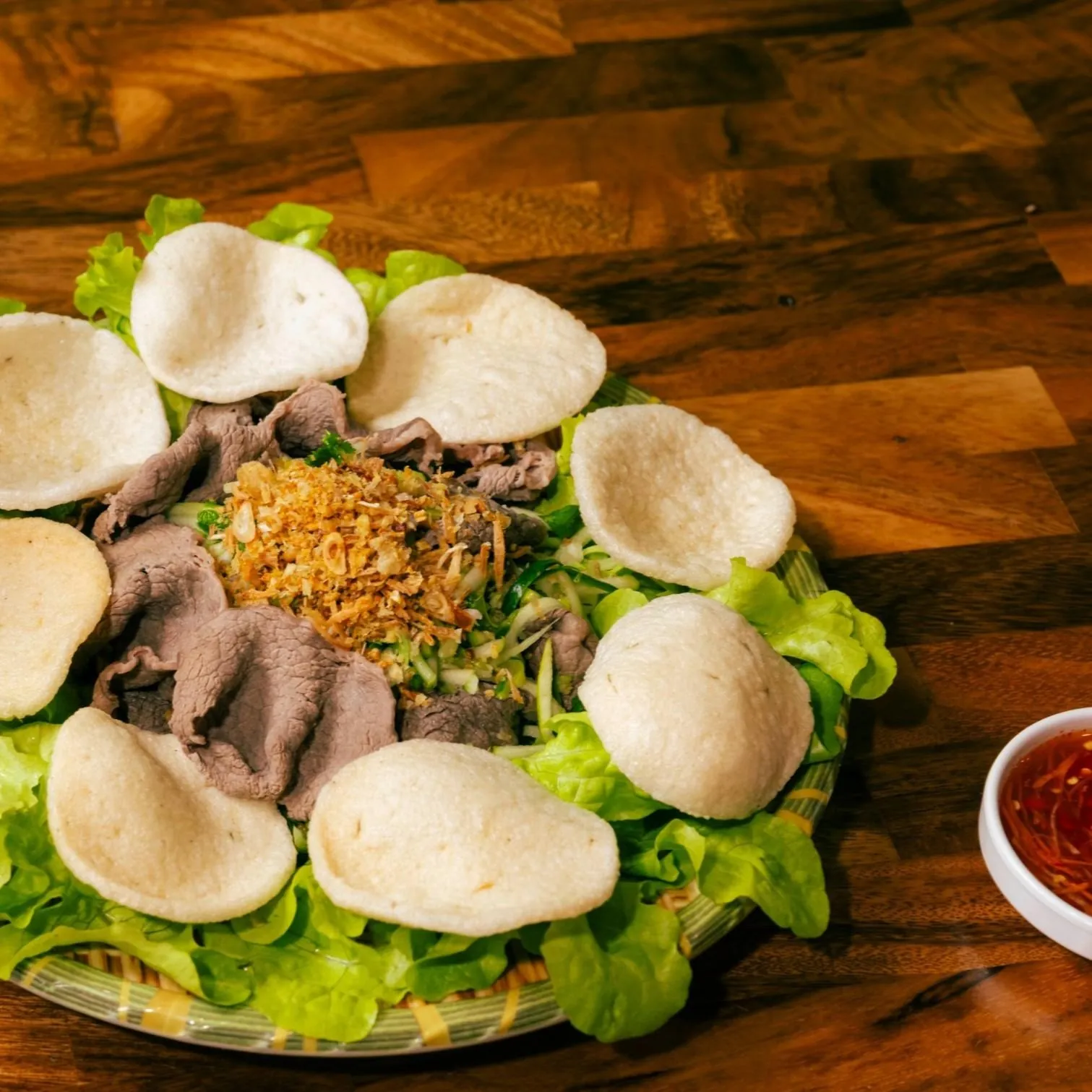 Gỏi Bò Tái Chanh at Bà Năm Adelaide — rare beef and shredded green apple salad with fried shallots, prawn crackers on lettuce, and nước chấm on the side