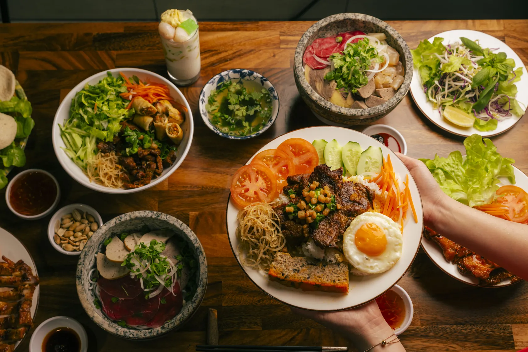 Stone bowl phở with chopsticks lifting red-coin rare beef noodles — walk from South Terrace to Bà Năm Adelaide