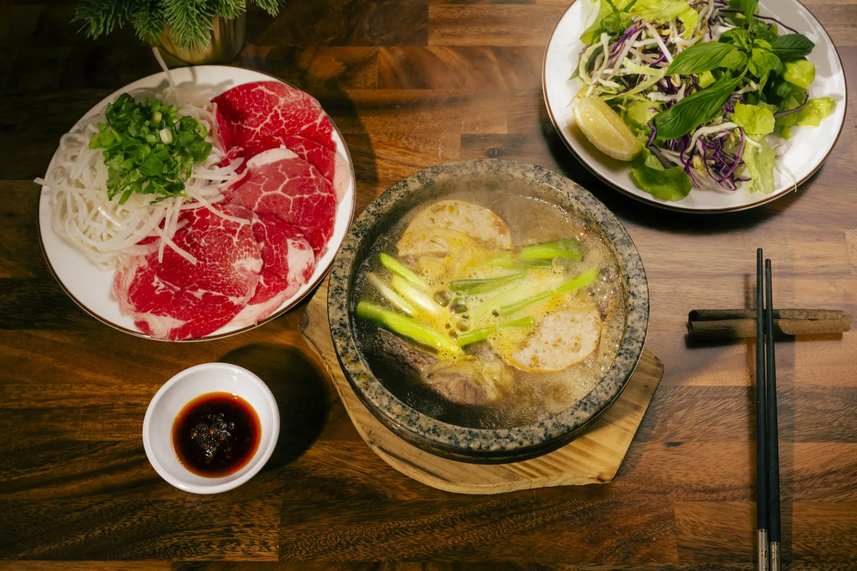 Stone bowl phở with fish cake, red-coin rare beef plate and herb salad — trip from North Adelaide to Bà Năm