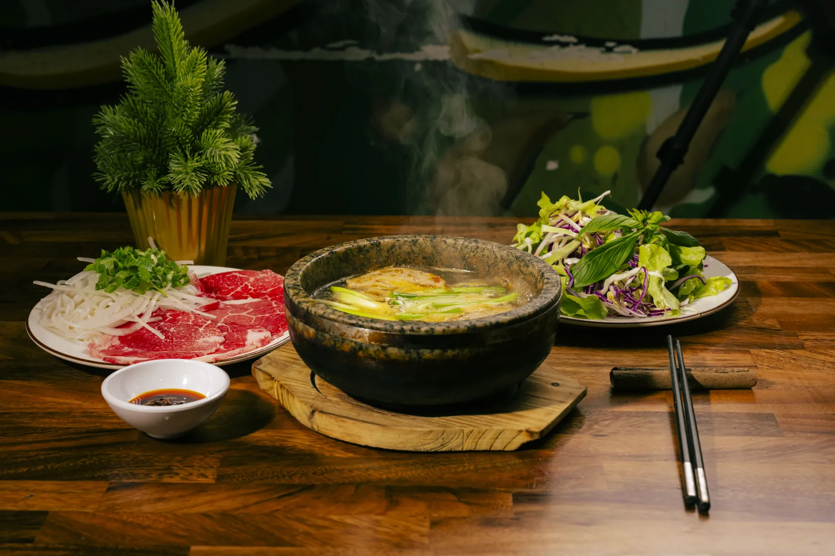 Steaming stone bowl phở with fish cake, red-coin rare beef plate and herb salad — trip from Unley to Bà Năm