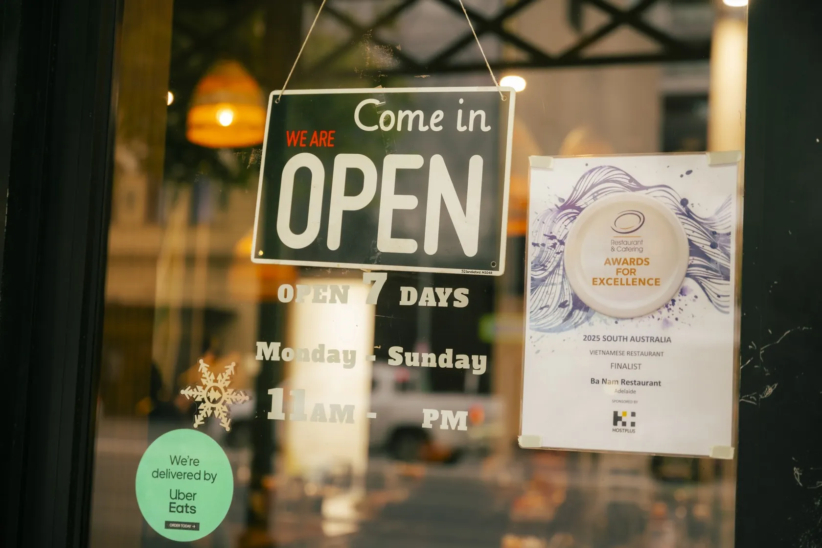 Bà Năm Restaurant front door at 65 Grote Street, Adelaide — open 7 days, with the 2025 SA Restaurant & Catering Awards finalist certificate in the window