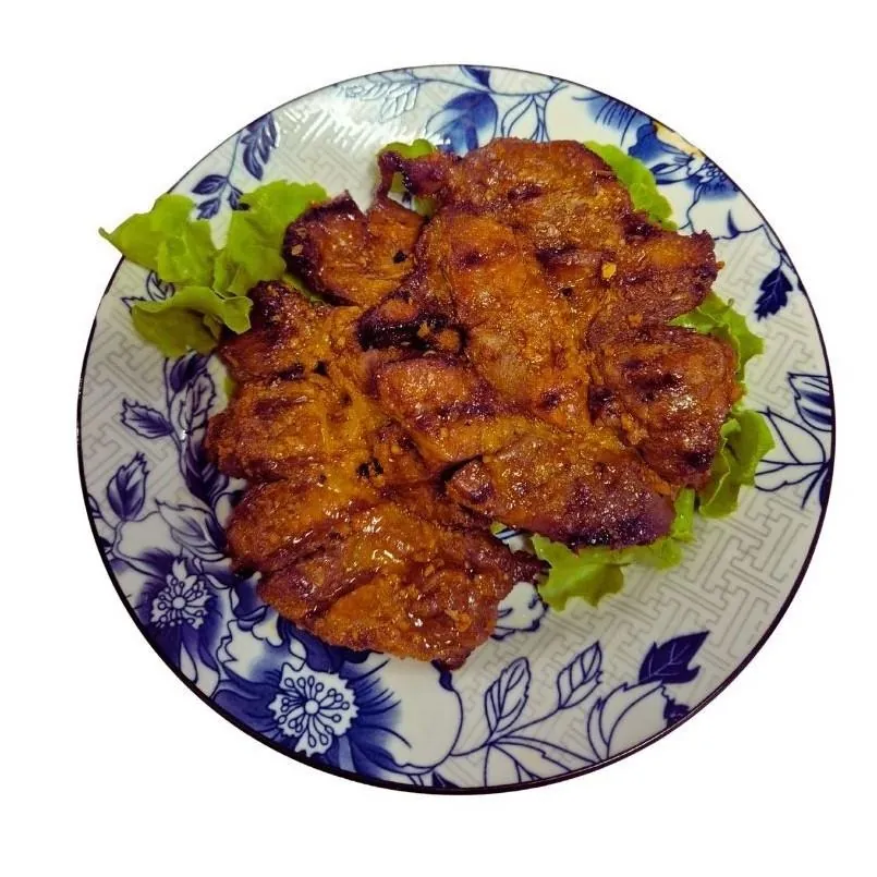 Sườn Nướng entrée at Bà Năm Adelaide Chinatown — pieces of char-grilled caramelised pork served on lettuce on a blue-and-white plate