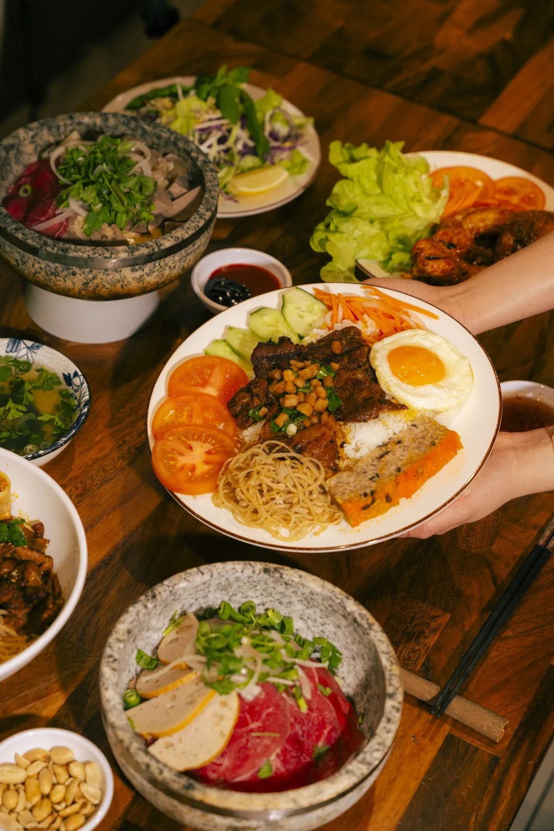 A full table of Vietnamese food at Bà Năm Restaurant, Adelaide — stone bowls, shared plates and noodles