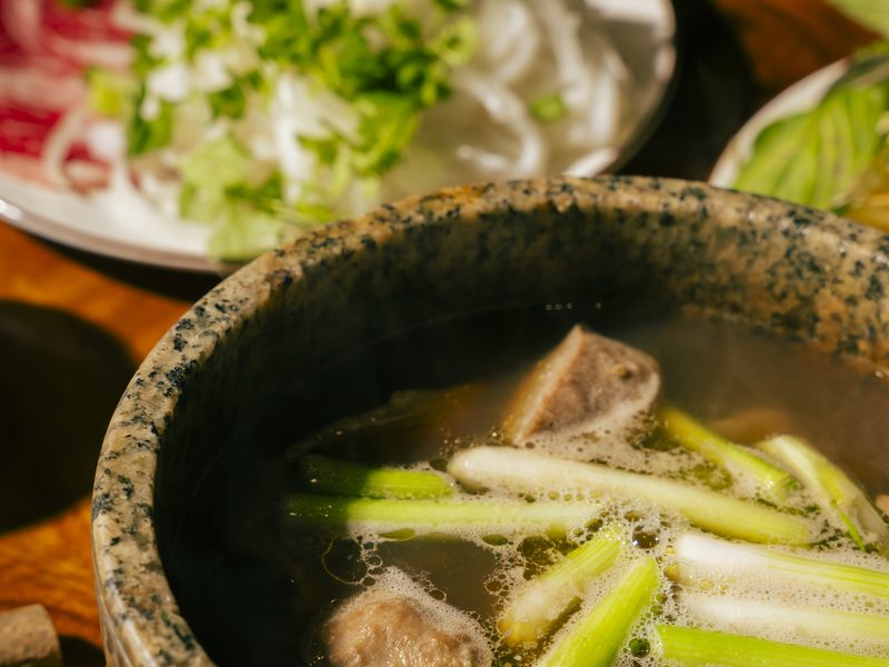 Phở Thố Đá at Bà Năm — signature stone-bowl pho with rare beef, still steaming at the table