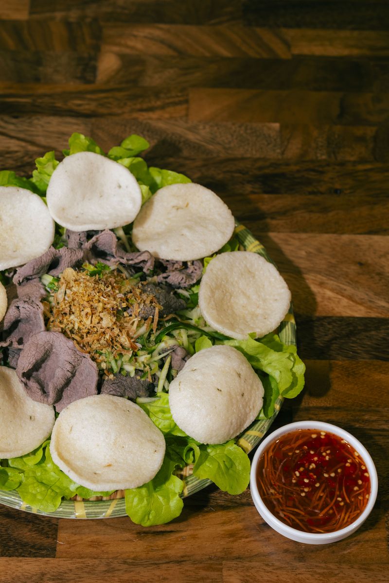 Gỏi Bò Tái Chanh — rare beef and green apple salad ringed with prawn crackers