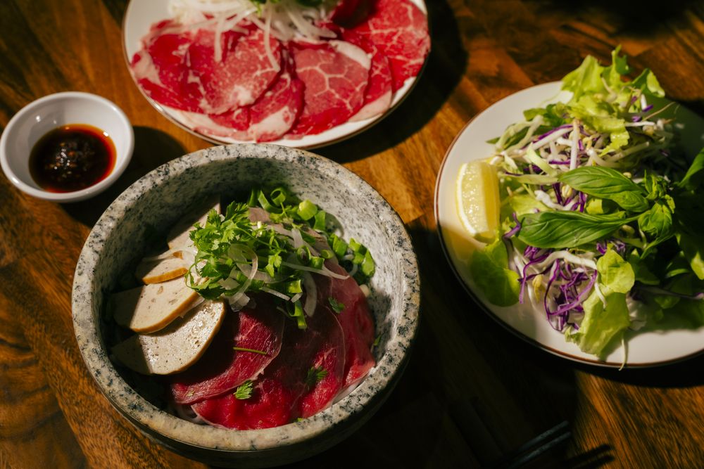 The Stone Bowl Set — stone bowl phở with a plate of rare beef, herbs and sauces